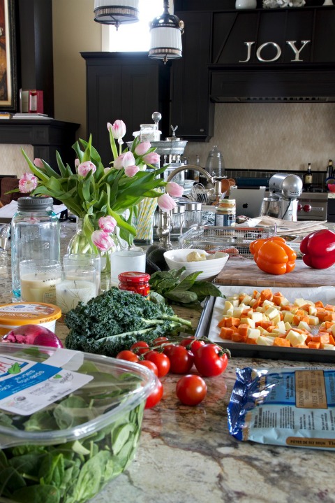 Kitchen counter covered in produce and tulips